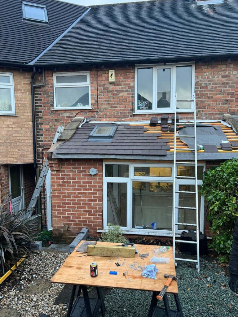 This is a photo of a roof extension that is having new roof tiles installed. This is a photo taken from the roof ridge looking down a tiled pitched roof on to a flat roof. Works carried out by New Ollerton Roofing Repairs