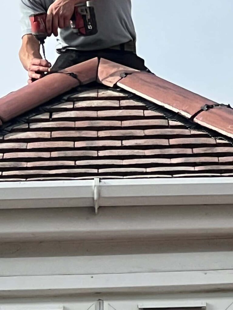 This is a photo of one of the operatives of New Ollerton Roofing Repairs installing new ridge tiles