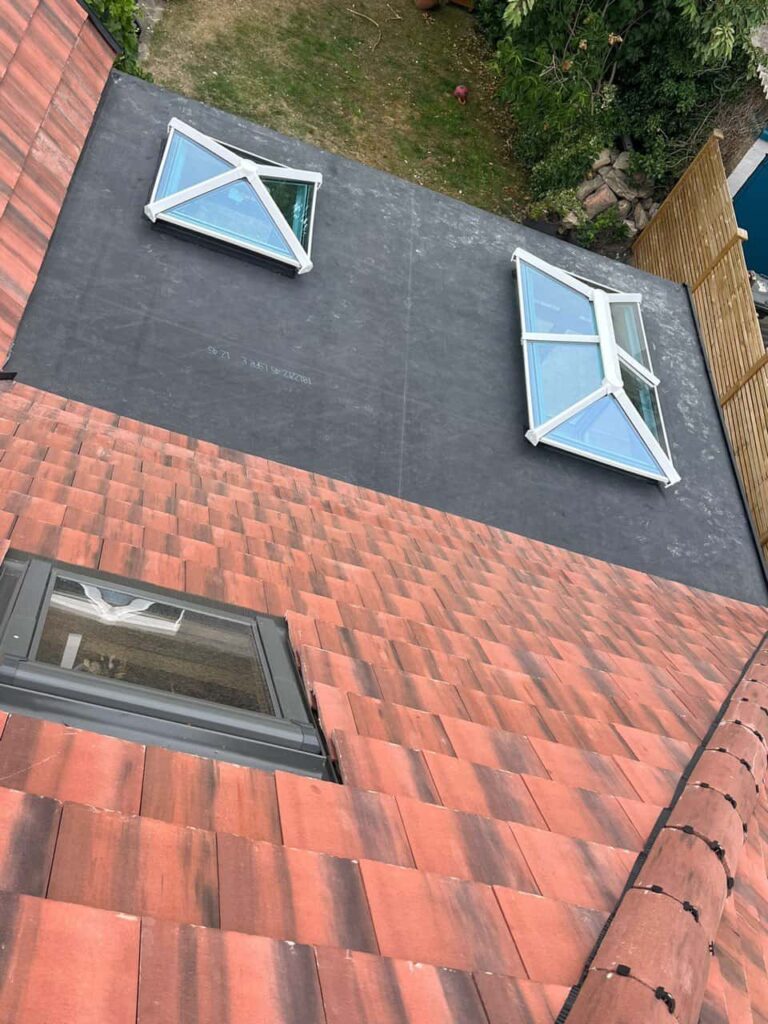 This is a photo taken from the roof ridge looking down a tiled pitched roof on to a flat roof. Works carried out by New Ollerton Roofing Repairs